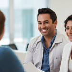 A Hispanic nurse giving an information to a husband and wife sitting in a medical clinic.