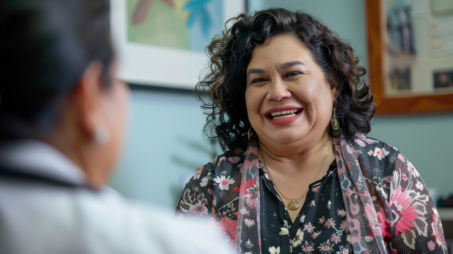 A happy slightly overweight Hispanic woman in her 60's is talking to a medical doctor in a clinic.